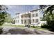 Two-story home with a charming balcony and shutters, nestled among lush trees on a beautiful day at 33 Duany Rd, Mount Pleasant, SC 29464