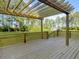 View of a wood deck with pergola overlooking a large, green backyard with a storage shed at 341 Sugar Hill Rd, Saint George, SC 29477