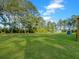 Expansive grassy backyard with mature trees and storage sheds at 341 Sugar Hill Rd, Saint George, SC 29477