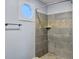 Bathroom shower featuring gray and tan tiling and a unique octagon window at 341 Sugar Hill Rd, Saint George, SC 29477