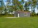 A detached gray one-car garage with a concrete drive sits amid green lawn and mature trees at 341 Sugar Hill Rd, Saint George, SC 29477