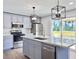 A modern kitchen features grey cabinets, stainless steel appliances, and a quartz countertop island at 341 Sugar Hill Rd, Saint George, SC 29477