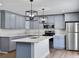 A bright kitchen features grey cabinets, stainless steel appliances and a large quartz countertop island at 341 Sugar Hill Rd, Saint George, SC 29477
