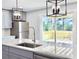 Kitchen featuring grey cabinets, stainless steel appliances, and a quartz countertop island overlooking the deck at 341 Sugar Hill Rd, Saint George, SC 29477