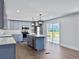 Well-lit kitchen with stainless steel appliances, gray cabinets, island, and sliding door to deck at 341 Sugar Hill Rd, Saint George, SC 29477