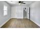 Bright, open living room features wood-look floors, ceiling fan, white trim, and a staircase at 341 Sugar Hill Rd, Saint George, SC 29477