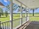 Inviting covered porch with white railings and columns overlooking picturesque fields at 341 Sugar Hill Rd, Saint George, SC 29477