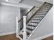 Staircase with white posts, black iron spindles, and stained handrail at 341 Sugar Hill Rd, Saint George, SC 29477