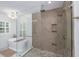 Stylish bathroom showcasing a glass shower with decorative tile, soaking tub, and modern lighting at 35 Campbell Dr, Charleston, SC 29407