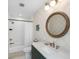 Well-lit bathroom with white subway tile, decorative wallpaper, and dark green vanity at 35 Campbell Dr, Charleston, SC 29407
