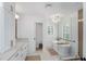 Bright bathroom with a soaking tub, glass shower, and white cabinets with bronze hardware at 35 Campbell Dr, Charleston, SC 29407