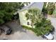 Aerial view of a green home with backyard and gravel driveway featuring multiple parked cars at 3.5 Kracke St # C, Charleston, SC 29403