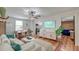 Bright living room featuring hardwood floors, ceiling fan, and open access to the kitchen and dining areas at 3.5 Kracke St # C, Charleston, SC 29403