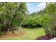 Picturesque backyard showcasing lush green lawn, mature trees, and beautifully landscaped borders at 3924 Regal Oak Ln, Johns Island, SC 29455