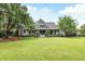 Charming home with a well-manicured lawn, beautiful landscaping, and a welcoming front porch at 3924 Regal Oak Ln, Johns Island, SC 29455