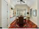 This home office features custom built-ins, large windows, and beautiful hardwood floors at 3924 Regal Oak Ln, Johns Island, SC 29455