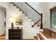 Beautiful staircase with wooden steps, black iron spindles, and a decorative chest at 3924 Regal Oak Ln, Johns Island, SC 29455