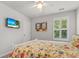Bedroom showcasing a large bed, window with plantation shutters, and mounted TV at 3952 Treebranch Cir Cir, Mount Pleasant, SC 29429