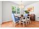 Bright dining room with hardwood floors, stylish chandelier, and large windows showcasing outdoor greenery at 3952 Treebranch Cir Cir, Mount Pleasant, SC 29429