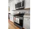 Close-up of the kitchen's stainless steel range and microwave with tile backsplash and granite countertops at 3952 Treebranch Cir Cir, Mount Pleasant, SC 29429