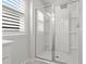 Beautiful shower with glass doors, built-in bench and tiled walls by a window with plantation shutters at 3952 Treebranch Cir Cir, Mount Pleasant, SC 29429