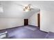 Finished attic featuring purple carpet, ceiling fan, and two doors at 415 Whitebark Dr, Ladson, SC 29456