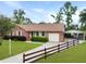 A charming single-story home with a brick exterior, attached garage, and well-maintained front yard with picket fence at 415 Whitebark Dr, Ladson, SC 29456