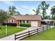 A charming single-story home with a brick exterior, attached garage, and well-maintained front yard with picket fence at 415 Whitebark Dr, Ladson, SC 29456