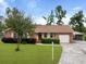 Charming brick home featuring a well-manicured lawn, mature landscaping, an attached garage, and carport at 415 Whitebark Dr, Ladson, SC 29456