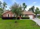 Charming brick home featuring a well-manicured lawn, mature landscaping, and an attached garage at 415 Whitebark Dr, Ladson, SC 29456