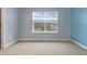 Bedroom with neutral carpet and paint, with window and blue accent wall at 4209 Climbing Tree Ct, Charleston, SC 29414