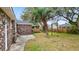 The backyard features a brick house, palm tree, green grass, and a storage shed at 4343 Helene Dr, North Charleston, SC 29418