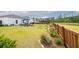 Large backyard with outdoor seating under a blue umbrella, and a scenic pond view beyond the wooden fence at 477 Spanish Wells Rd, Summerville, SC 29486