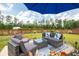 Backyard with a patio set under a blue umbrella with vibrant flowers and a privacy fence at 477 Spanish Wells Rd, Summerville, SC 29486