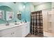 Well-appointed bathroom boasts a dual sink vanity, modern shower with unique curtain, and a bright, clean design at 477 Spanish Wells Rd, Summerville, SC 29486