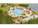 An aerial view of a beautifully landscaped community pool area with ample seating, a playground, and a tranquil pond at 477 Spanish Wells Rd, Summerville, SC 29486