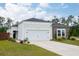 Charming single-story home with light siding, stone accents, well-manicured lawn, and a two-car garage at 477 Spanish Wells Rd, Summerville, SC 29486
