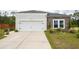 The home has a two-car garage with black accents, landscaping, and a concrete driveway at 477 Spanish Wells Rd, Summerville, SC 29486