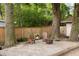 Relaxing backyard with Adirondack chairs, a fire pit, mature trees, and a privacy fence at 5037 Alpha St, North Charleston, SC 29405
