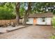Charming home featuring a cozy gravel area with Adirondack chairs and a fire pit, nestled under mature trees at 5037 Alpha St, North Charleston, SC 29405