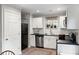 Modern kitchen with white cabinets, black countertops, stainless steel appliances and a charming overhead light at 5037 Alpha St, North Charleston, SC 29405