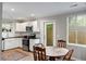 Eat-in kitchen with white cabinets, stainless steel appliances, and views of the backyard at 5037 Alpha St, North Charleston, SC 29405