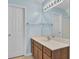Bathroom featuring a wood vanity, light blue walls, a large mirror, and white painted door at 5223 Fernland Way, Charleston, SC 29420