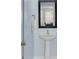 Powder room featuring a stylish pedestal sink, framed mirror, and soft blue walls at 5223 Fernland Way, Charleston, SC 29420
