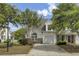 Charming two-story home with a one car garage, well-maintained landscaping and a paved driveway on a sunny day at 5223 Fernland Way, Charleston, SC 29420