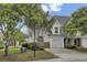 Charming two-story home with a one car garage, well-maintained landscaping and a paved driveway on a sunny day at 5223 Fernland Way, Charleston, SC 29420