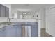 Open-concept kitchen with stainless steel dishwasher, granite countertops, and gray cabinets at 5223 Fernland Way, Charleston, SC 29420