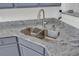 Close-up of a modern stainless steel sink with granite countertops and gray cabinets at 5223 Fernland Way, Charleston, SC 29420