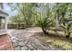Spacious backyard featuring a stone patio, mature trees, and a charming pergola at 543 Castle Hall Rd, Mount Pleasant, SC 29464