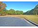 Open green space between parking lot and mature trees under a bright, clear, blue sky at 543 Castle Hall Rd, Mount Pleasant, SC 29464